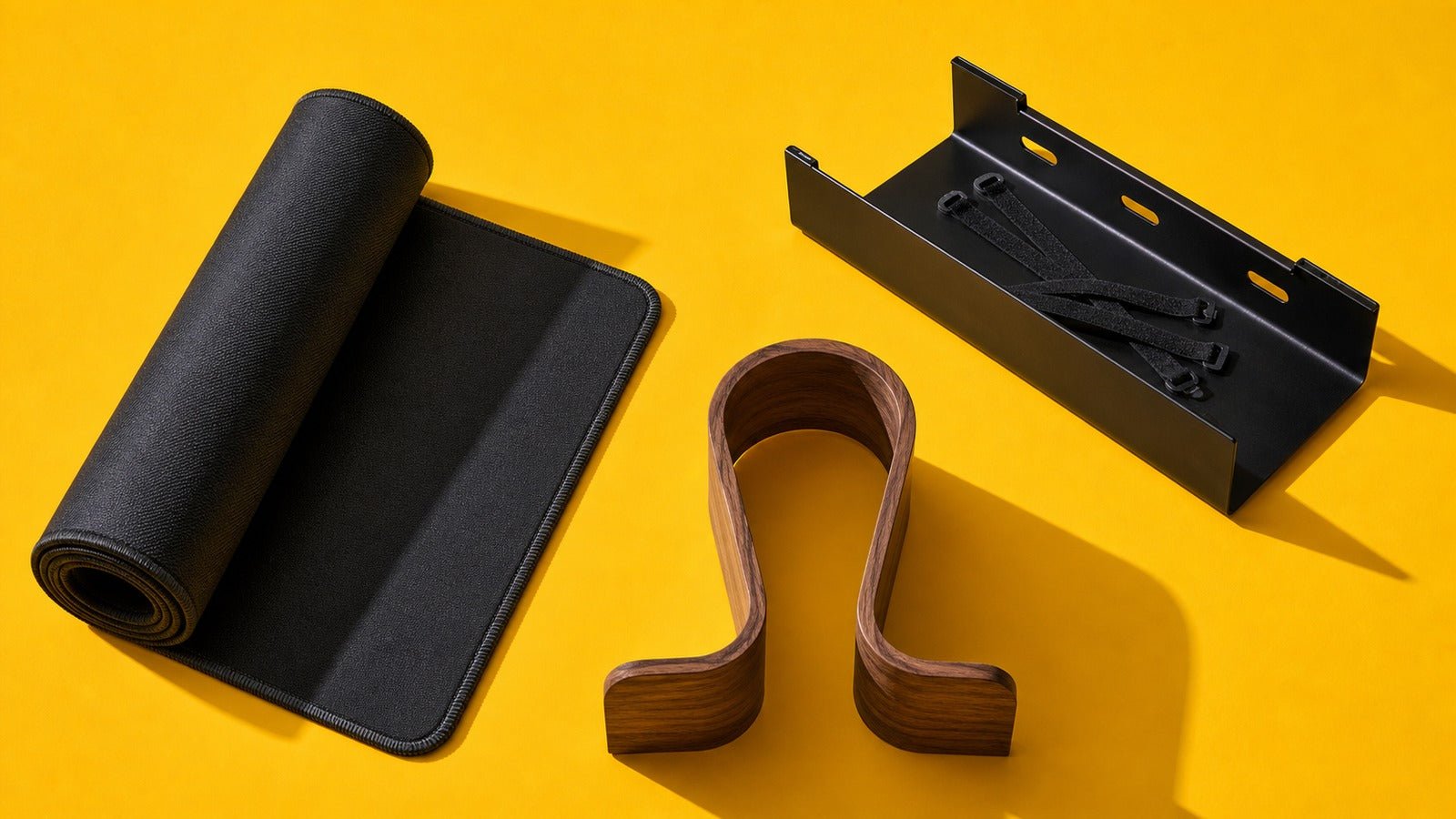 Desk mat, cable tray, and walnut headphone stand arranged as three upgrades on yellow